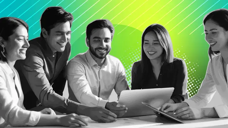 Five colleagues smiling while reviewing work together on a laptop and a tablet